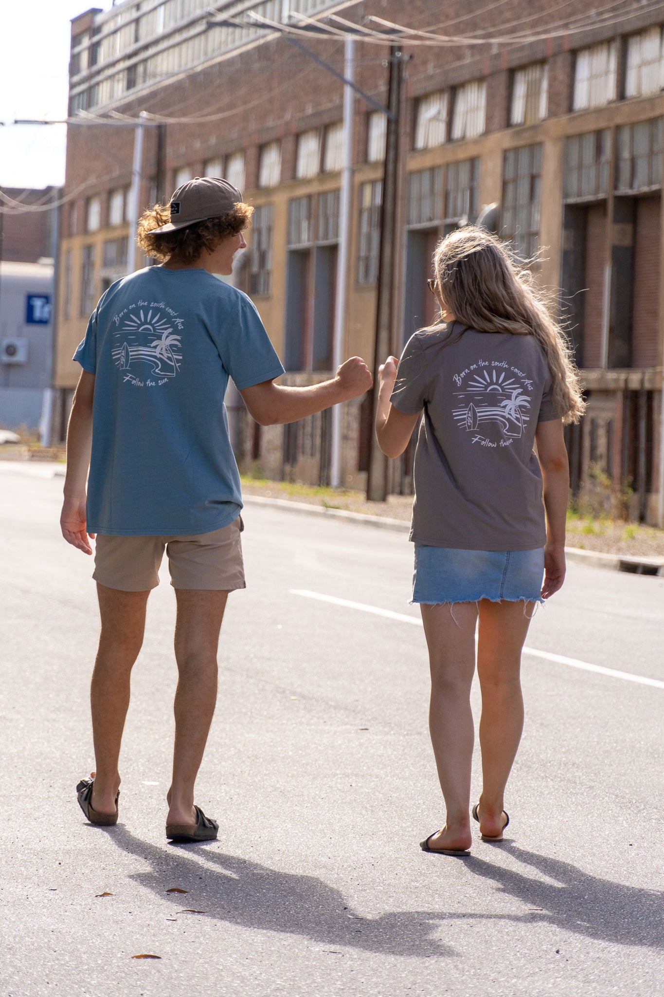 OSOM south coast tee. tees in blue and dust colours. beach design on back of shirt. friends walking together. ethically made clothing.